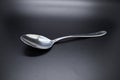 Silver spoon set against dark background