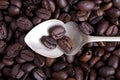 Silver spoon on spilled coffee beans Royalty Free Stock Photo
