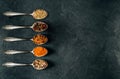 Silver spoons with various spices arranged on a slate Royalty Free Stock Photo