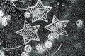 Silver stars and bokeh of garland on a black background, defocused effect. Abstract Christmas backdrop Royalty Free Stock Photo