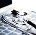 Silver stethoscope over laptop keyboard Royalty Free Stock Photo