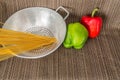 Silver strainer with spaghetti and peppers