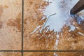 A silver straw sits among spilt milk splashed across a concrete floor Royalty Free Stock Photo