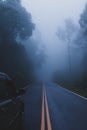 Silver SUV car driving on a mountain road in fog Royalty Free Stock Photo