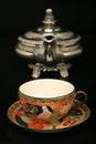 Silver teapot and an antique chinese cup of tea Royalty Free Stock Photo