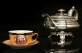 Silver teapot and an antique chinese cup of tea Royalty Free Stock Photo