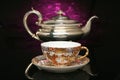 Silver teapot and an antique chinese cup of tea Royalty Free Stock Photo