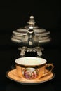 Silver teapot and an antique chinese cup of tea Royalty Free Stock Photo