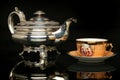 Silver teapot and an antique chinese cup of tea Royalty Free Stock Photo