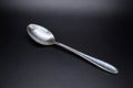 Silver teaspoon set against dark background