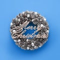 Silver Text Merry Christmas on a silver Christmas wreath on a blue background. Top view