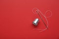 Silver thimble, needle and thread on red background, flat lay. Space for text Royalty Free Stock Photo