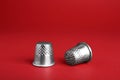 Silver thimbles on red background. Sewing accessory Royalty Free Stock Photo