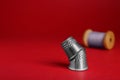 Silver thimbles on red background, space for text. Sewing accessories Royalty Free Stock Photo