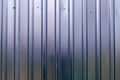 Silver tin iron wall with vertical and diagonal stripes from a metal profile of a metal sheet. Texture, background Royalty Free Stock Photo