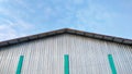 A silver tin roof of sport center building with a bright blue sky background. Royalty Free Stock Photo