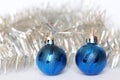 Silver tinsel and two blue balls - classic Christmas decorations on a white background. Holiday trends 2020. Happy New Year Royalty Free Stock Photo