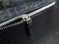 Silver-tone zip fastener on a black leather bag