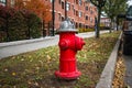 Silver-topped traditional red American style fire hydrant outside a modern housing block Royalty Free Stock Photo
