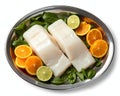 A silver tray with fresh halibut fillets and slices of orange and lime Royalty Free Stock Photo