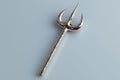 Silver trident on a light gray background Royalty Free Stock Photo