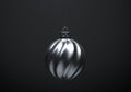 Silver twisted striped Christmas ball. Hanging against dark gray background