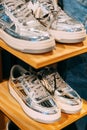 silver unisex sneakers shoes on shelf display in shop mall store. Store Of Shopping Center. retail sale Royalty Free Stock Photo