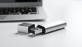 Silver USB Flash Drive With Cap Open Next to Laptop Keyboard on White Surface USB drive Royalty Free Stock Photo
