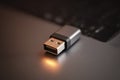 Close up of a silver USB flash drive resting on a laptop keyboard in a well-lit workspace during the day Royalty Free Stock Photo