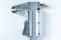 Silver Vernier calipers hanging on white wall Royalty Free Stock Photo