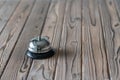 Silver vintage bell on wooden rustic reception desk with copy space. Hotel service. Selective focus. Royalty Free Stock Photo