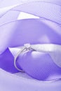 Silver wedding diamond ring on white sparkle background with purple ribbon Royalty Free Stock Photo