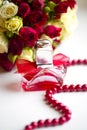 Silver wedding rings with perfume bottle and wedding bouquet of red and white roses Royalty Free Stock Photo