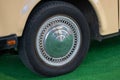 Silver wheel cap on old car parked on lawn