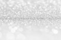 Silver white abstract light grey background, shining lights, sparkling glittering Christmas lights. Blurred abstract holiday backg Royalty Free Stock Photo