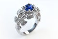 Silver or white gold ring with diamonds and blue sapphires closeup. Precious gems and metals, natural gemstone jewelry Royalty Free Stock Photo