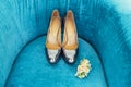 Silvering bride shoes with wedding boutonniere on blue couch