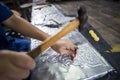 Silversmiths tools on the silver workplace. Silversmith using hammer and steel engraved pattern on silver plate for accessory