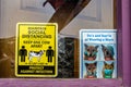 Silverton Co USA Covid safety signs in rustic window with purple wooden frame - keep one cow apart and mask safety