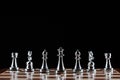 Silvery chess figures standing on chessboard