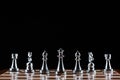 Silvery chess figures standing on chessboard