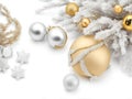 Silvery and golden christmas ornaments next to a white christmas tree on