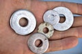 Silvery iron washers in a man`s hand