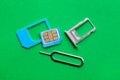 SIM card, tray and ejector on green background, flat lay Royalty Free Stock Photo