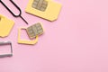 SIM card, tray and ejector on pink background, flat lay. Space for text