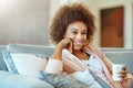 Simmering down with a cup of tea. Portrait of a young woman relaxing with a warm beverage at home.