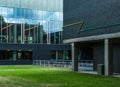 Simmetry in Modern Architecture. Reflection of clouds in glass windows and green lawn in front. Technical University of Royalty Free Stock Photo