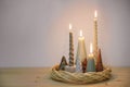 Simple advent decoration in natural colors with different candles and small artificial Christmas trees arranged in a wreath from Royalty Free Stock Photo