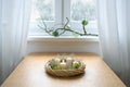 Simple advent wreath with moss and white candles, the first one is lit, on a table near the window on a snowy winter day, holiday Royalty Free Stock Photo