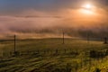 Simple aerial power lines at foggy morning in summer countryside